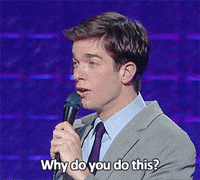 A boyish looking man in a tie holds a microphone and asks "Why do you do this?"