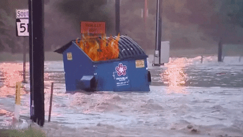 Flaming dumpster floating down a flooded street