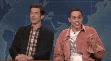 Pete Davidson of SNL holds up two fingers and shouts "Two!" as John Mulaney looks on, laughing